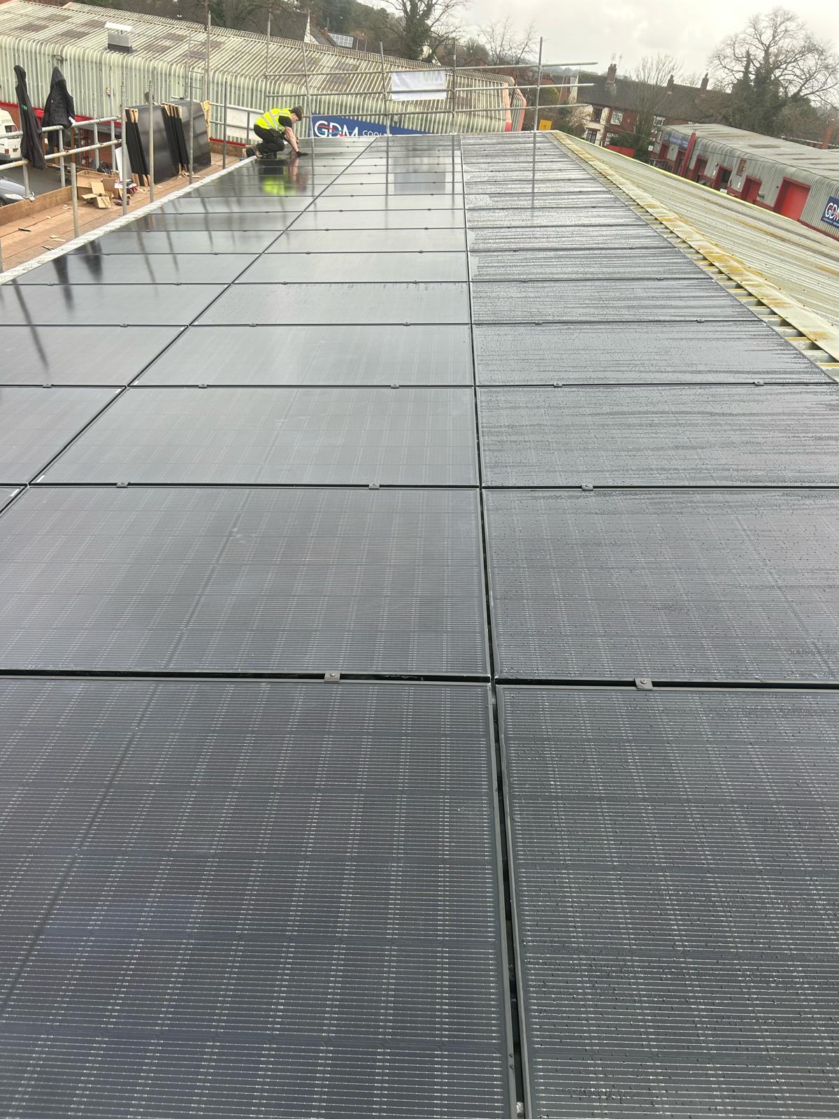 Solar panels being installed on an industrial warehouse